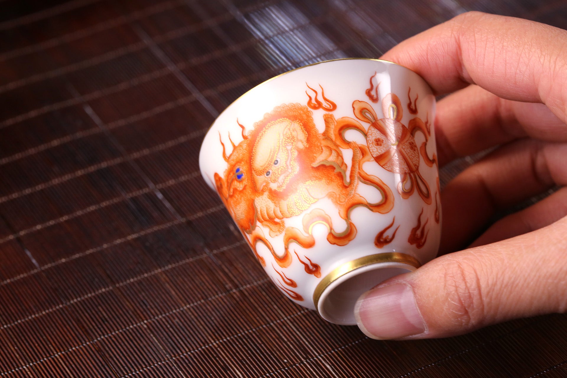 Iron-Red Tasting Cup with Gilded Lion Dance & Great Auspiciousness Motifs