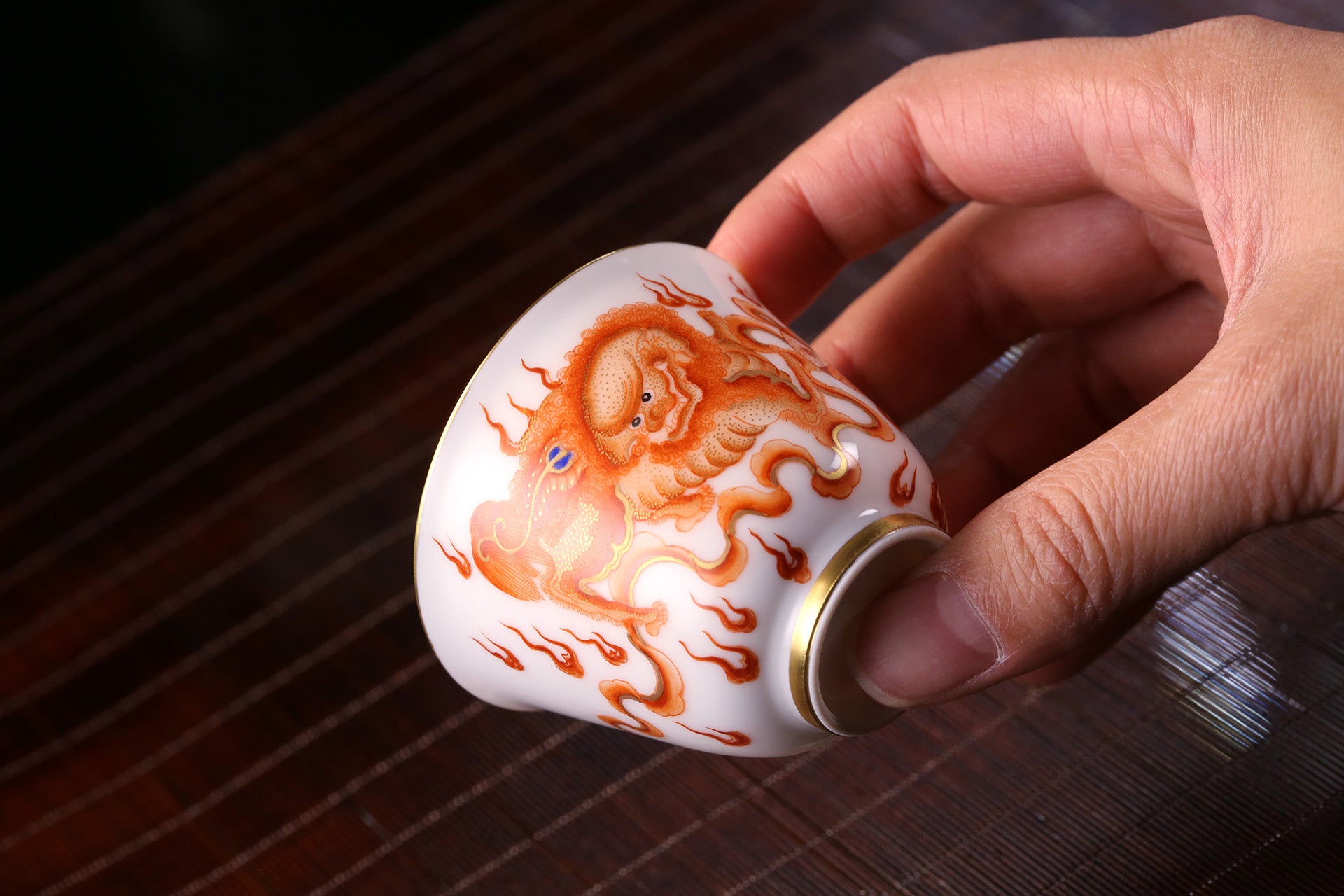 Iron-Red Tasting Cup with Gilded Lion Dance & Great Auspiciousness Motifs